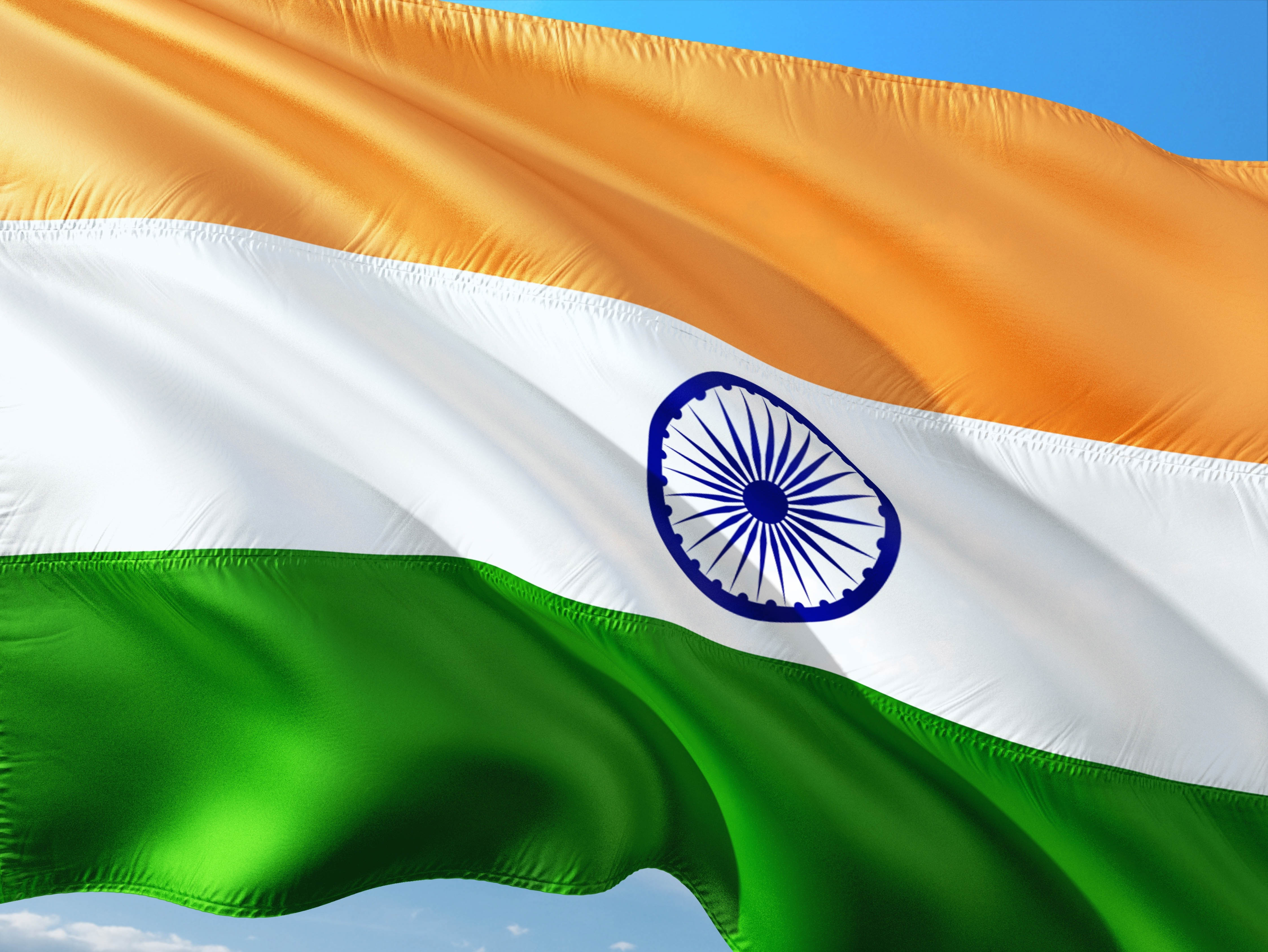 The flag of India waving against a blue sky